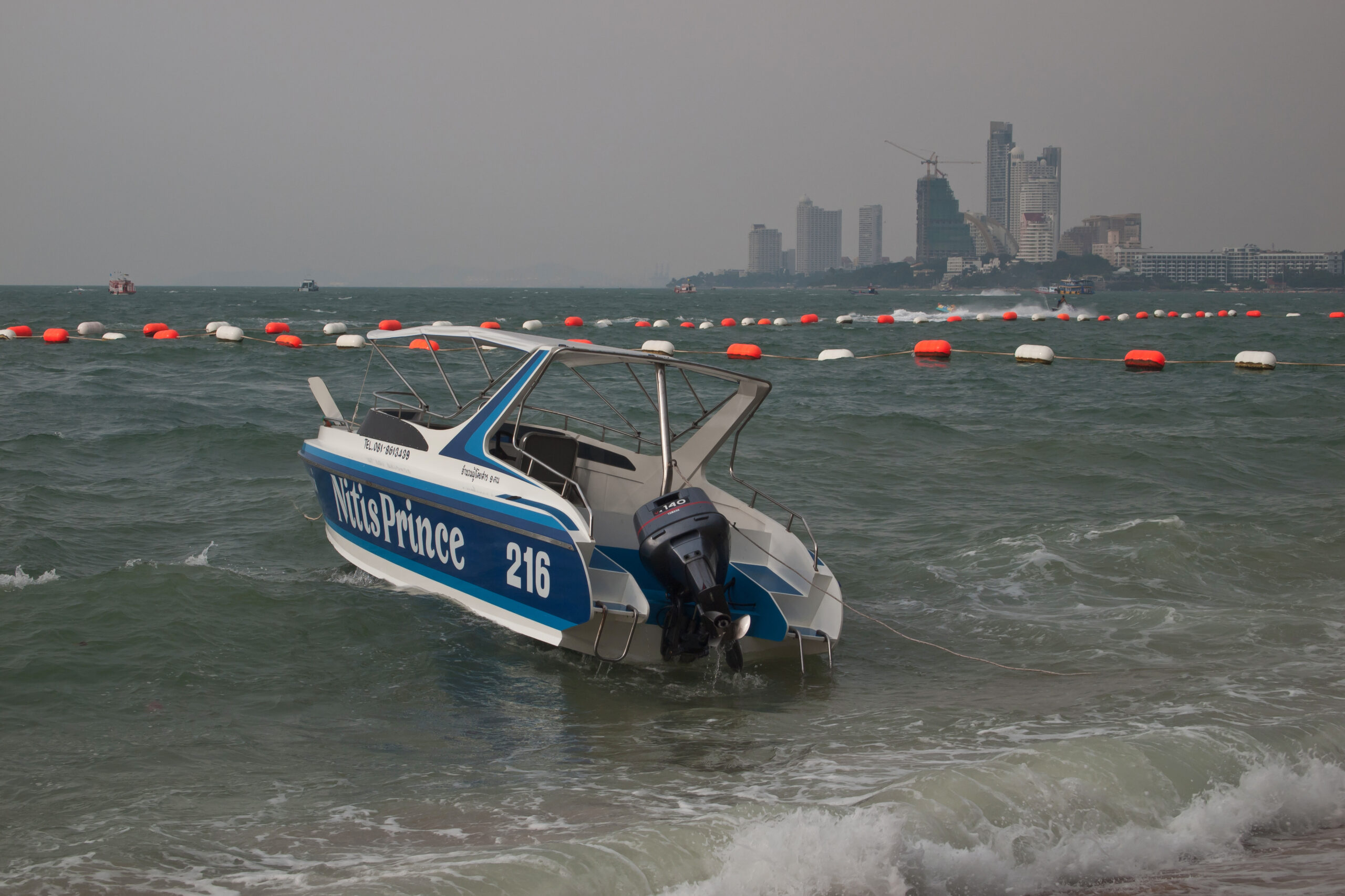 Playa de Pattaya con embarcación y costa urbana en Tailandia