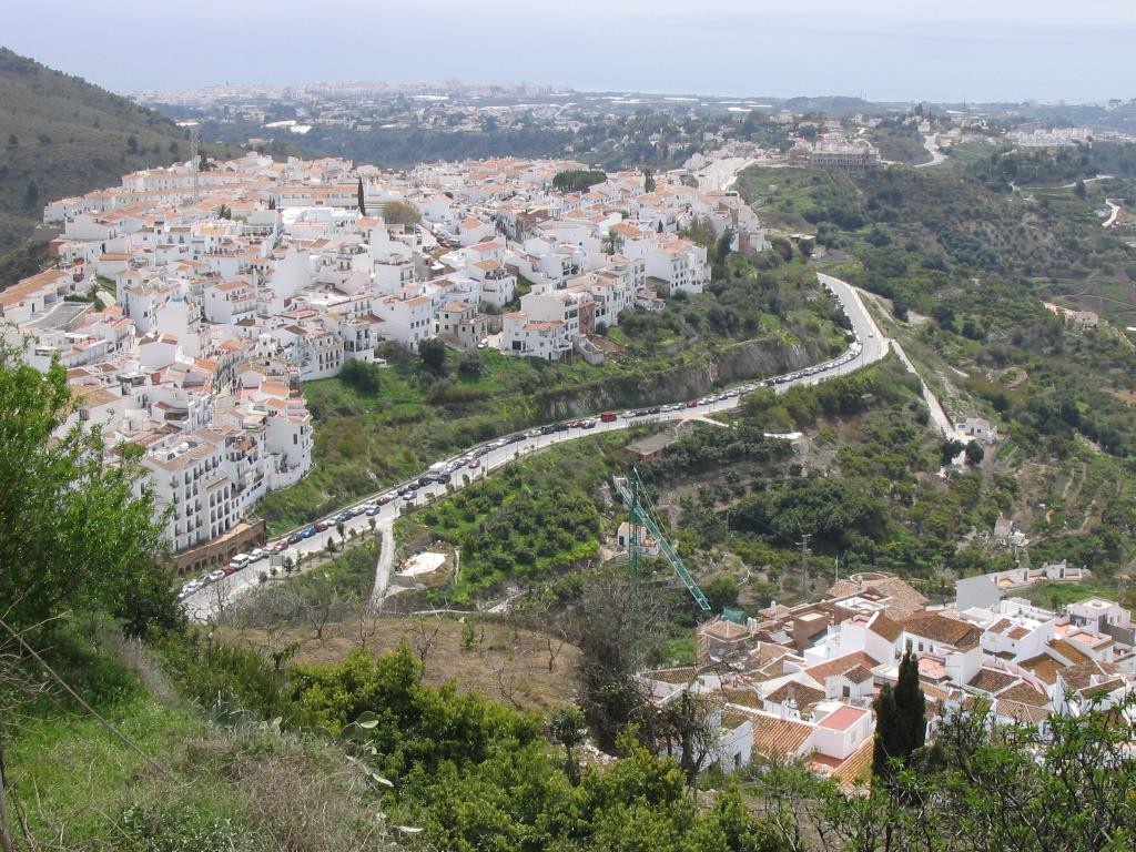 Calle blanca de Frigiliana con macetas y flores